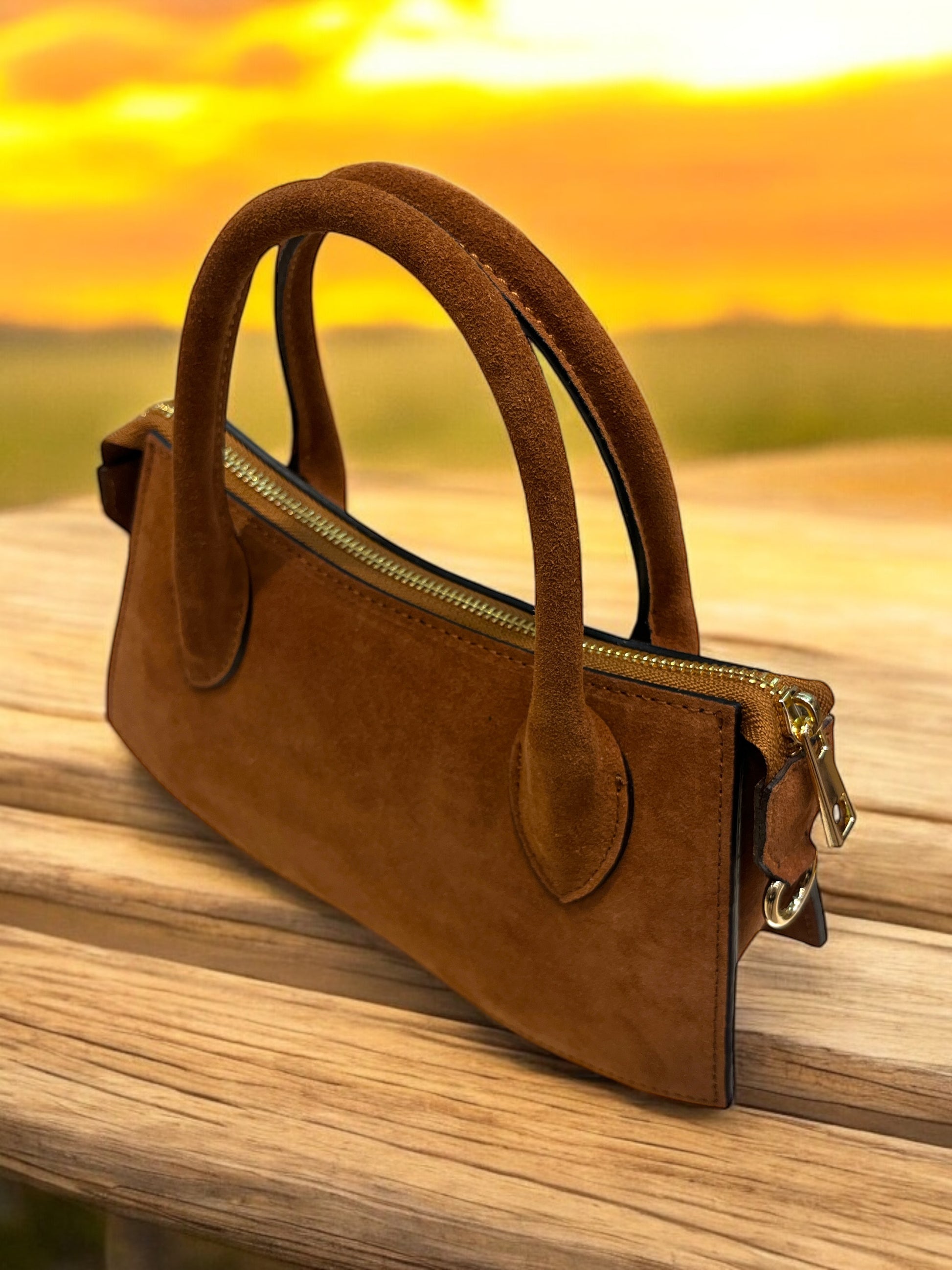 Borsa in pelle scamosciata marrone chiaro con maniglie comode e dettagli metallici, elegante e versatile.
